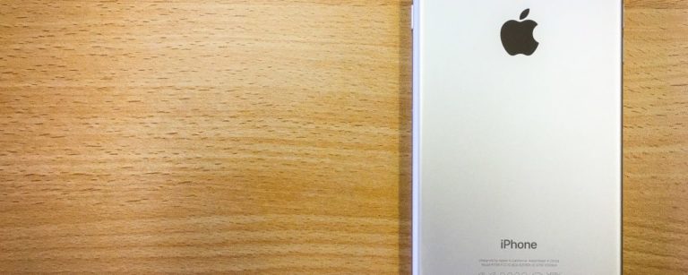 iPhone face down on woodgrain tabletop