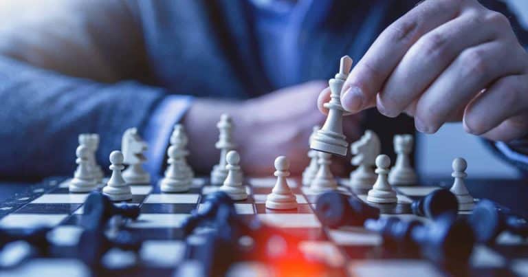 A man is playing chess on a chess board.