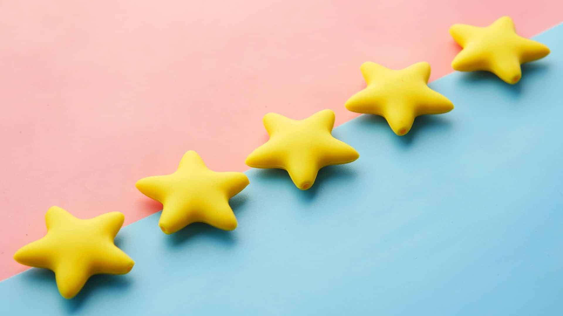 Five yellow stars on a pink and blue background.