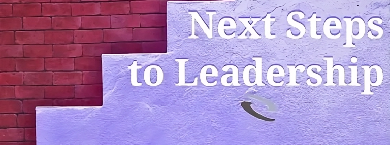 A brick wall painted to resemble a staircase, with the text "Next Steps to Leadership" in large white letters.