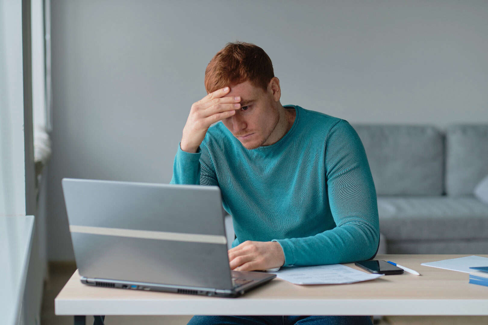 Depressed man staring at laptop